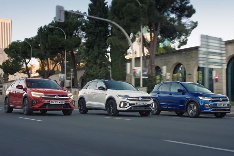 3 VW SUVs driving down a city road.