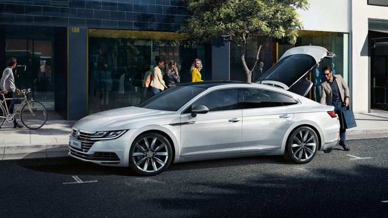 A white Arteon with a man opening a back door
