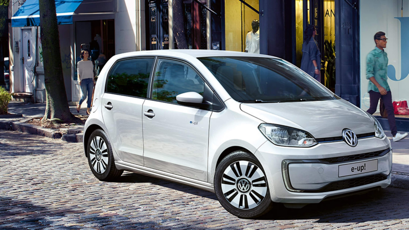 A white Volkswagen e-up! parked on a road