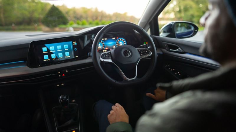 Interior of the new Golf 8 shot from just behind the drivers seat, showing the steering wheel and 10-inch display screen