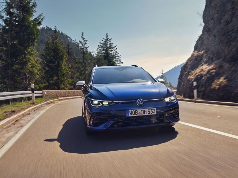 A blue VW Golf R Estate driving down a mountain road