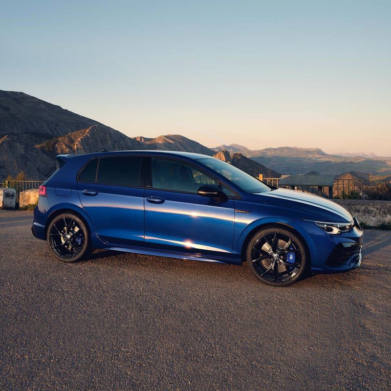 The VWR Golf R “20 Years” in blue drives down a mountain road