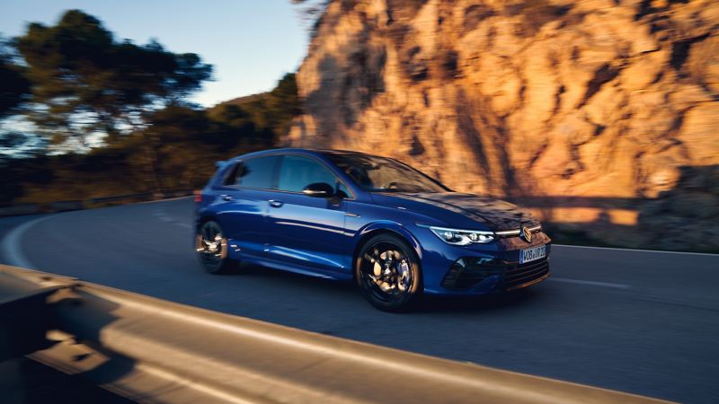 The VWR Golf R “20 Years” in blue drives down a mountain road