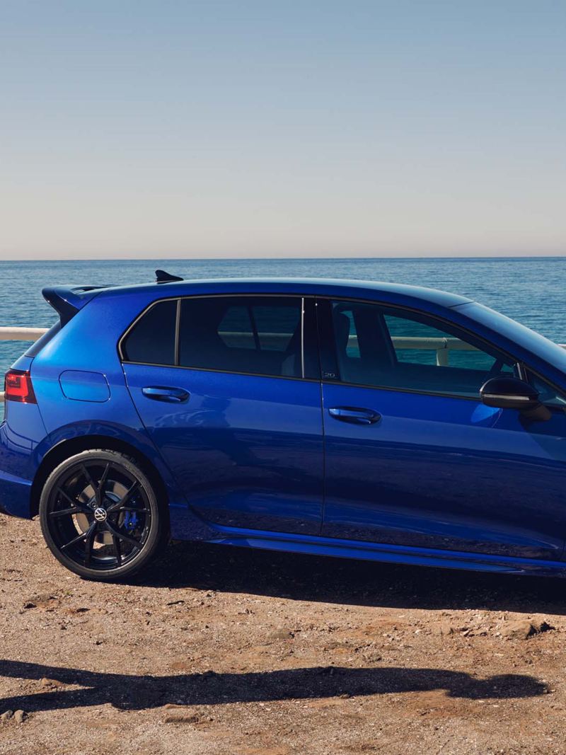  man walks away from his parked blue VWR Golf R “20 Years”