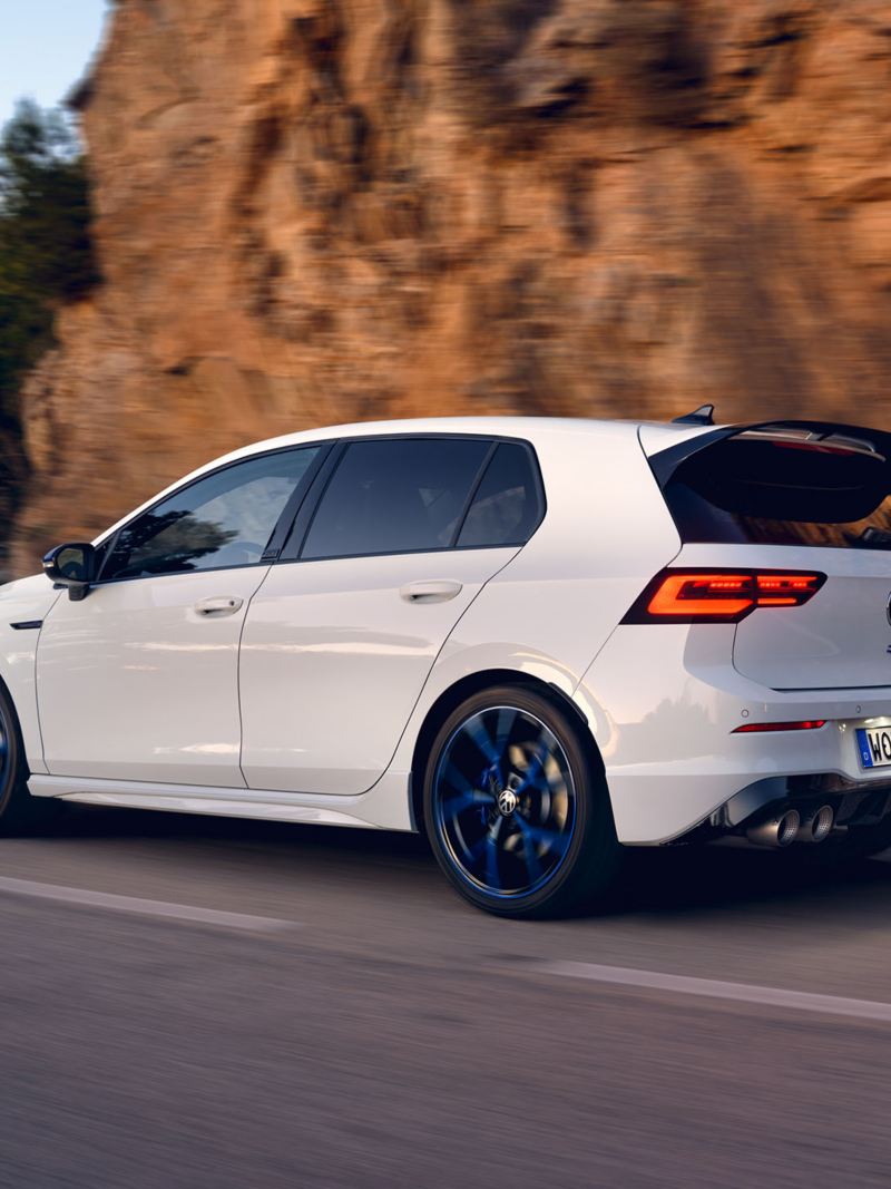 The white VWR Golf R “20 Years” drives along a road