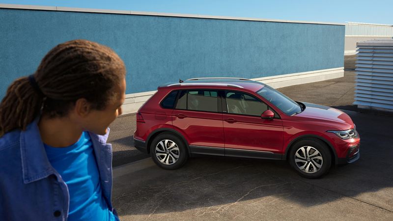 A man looking at a stunningly looking red Tiguan ACTIVE in the background