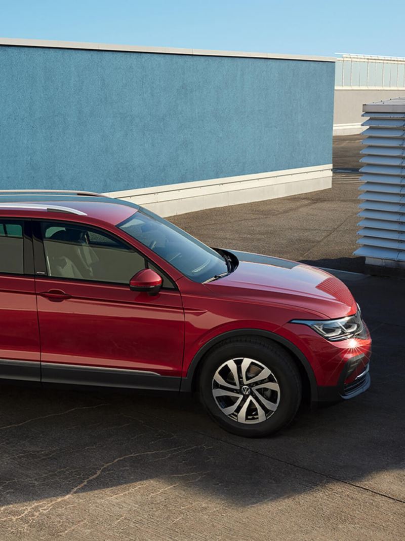 A man looking at a stunningly looking red Tiguan ACTIVE in the background