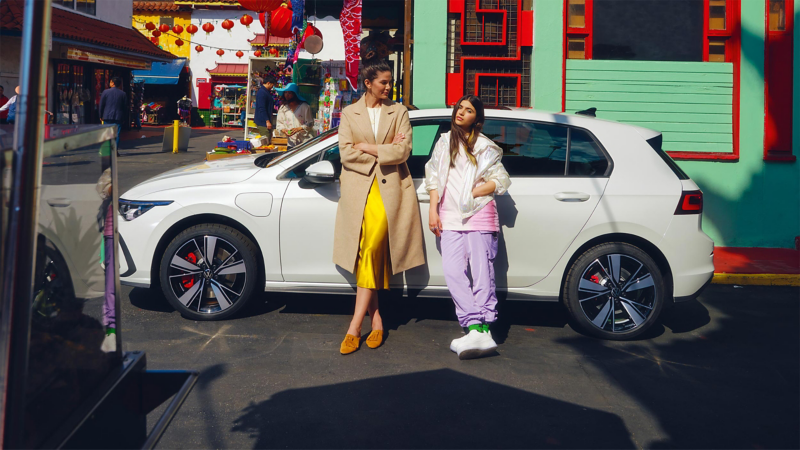 A woman and her daughter leaning against  a Golf GTE