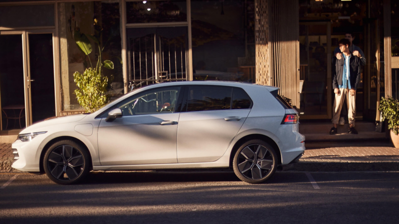 A white Golf parked outside a café