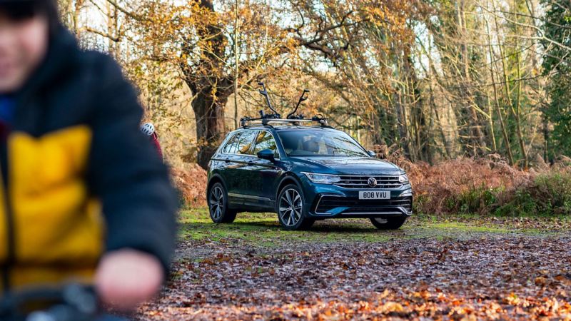 A blue VW Tiguan parked in a field in autumn