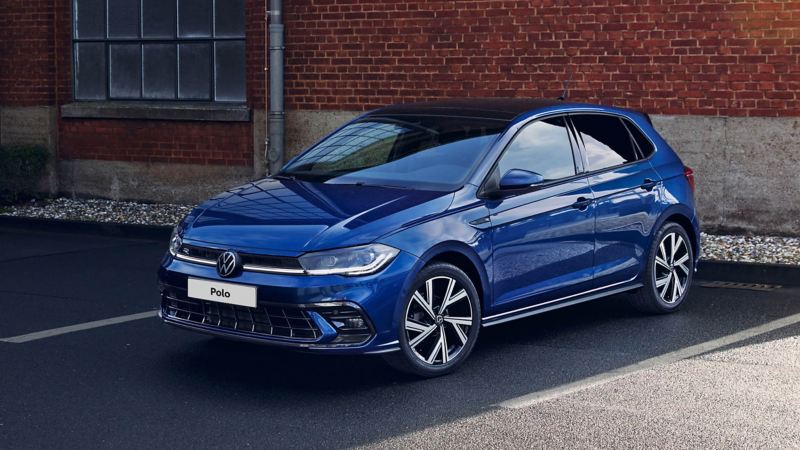 A blue Polo in a parking bay outside an old studio building 