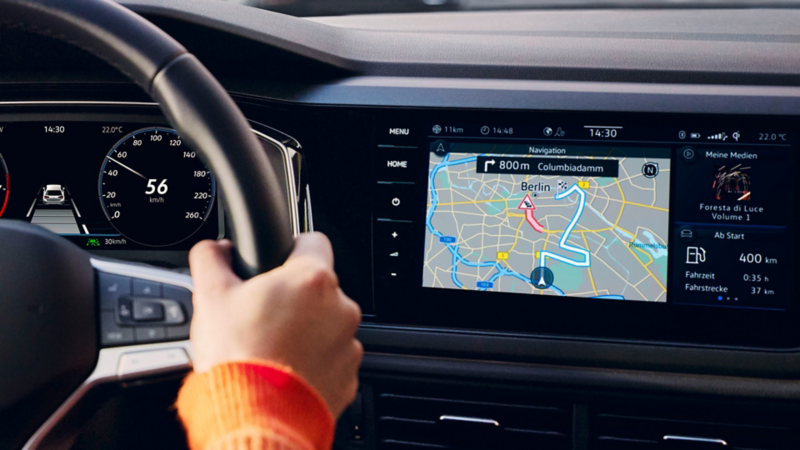 A woman sits in the driver's seat of the VW Polo and looks ahead at the optional Digital Cockpit Pro