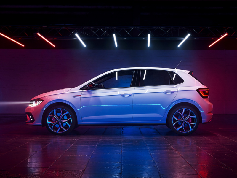 View of the side of a white VW Polo GTI with tinted rear windows, GTI badge on the fender and optional 18-inch "Faro" wheels.