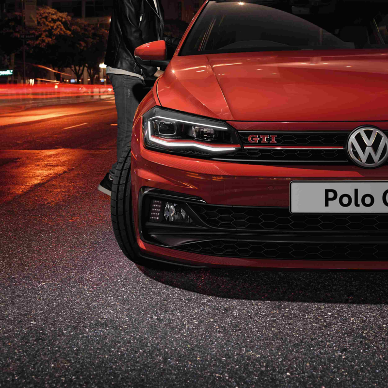 A close-up of the front grill of a red Volkswagen Polo