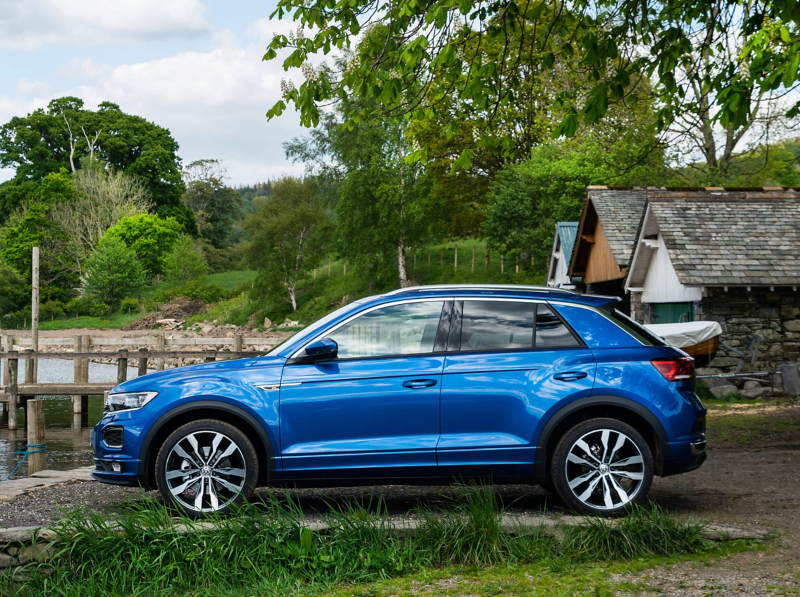 A blue T-Roc parked on the edge of a lake