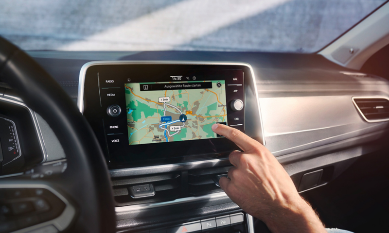VW T-Roc interior, detailed view of the Discover Media infotainment system, that is currently being operated by one hand 