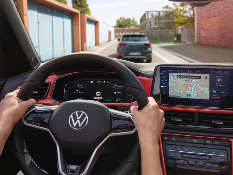 Interior of VW T-Roc cabriolet with person's hands on steering wheel