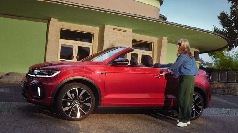 Person opening door of red VW T-Roc Cabriolet