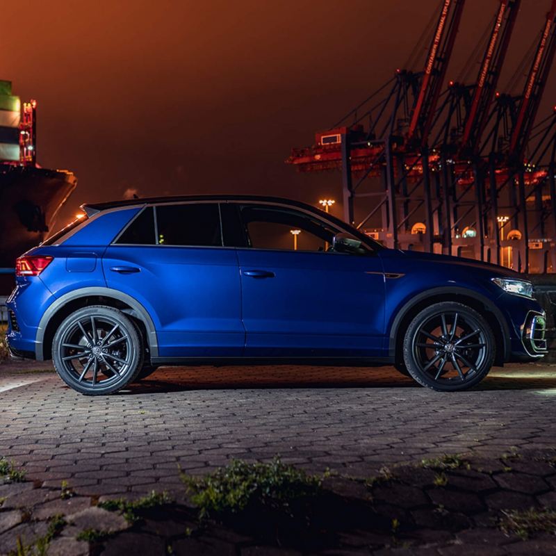 A blue VW T-Roc R parked at a dock at night