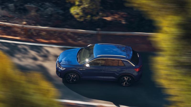 Aerial shot of a blue VW t-roc r driving down a country road