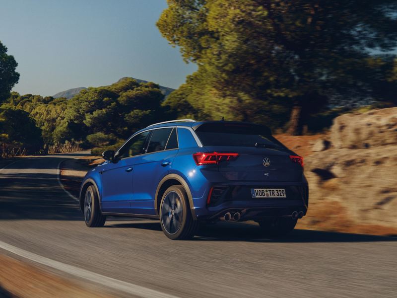 Rear shot of blue VW T-Roc R driving down main road