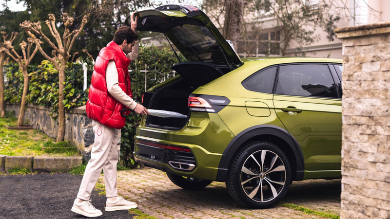 Photo showing a man loading the rear storage of a Volkswagen Taigo