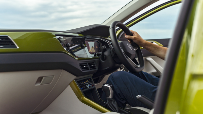 A side shot of a person sitting in the drivers seat of a Taigo