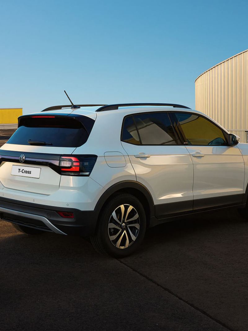 White VW T-Roc ACTIVE parked in an urban environment with an open luggage compartment.