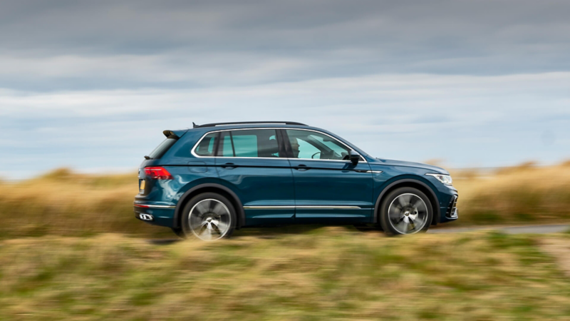 A blue Volkswagen Tiguan being driven on a country road