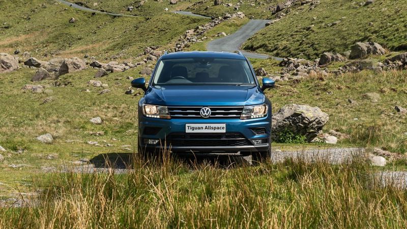 A blue Tiguan Allspace in the countryside, parked a mountain road.