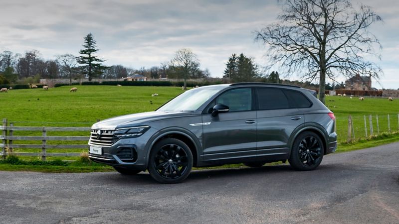 A grey Touareg on a park-side road