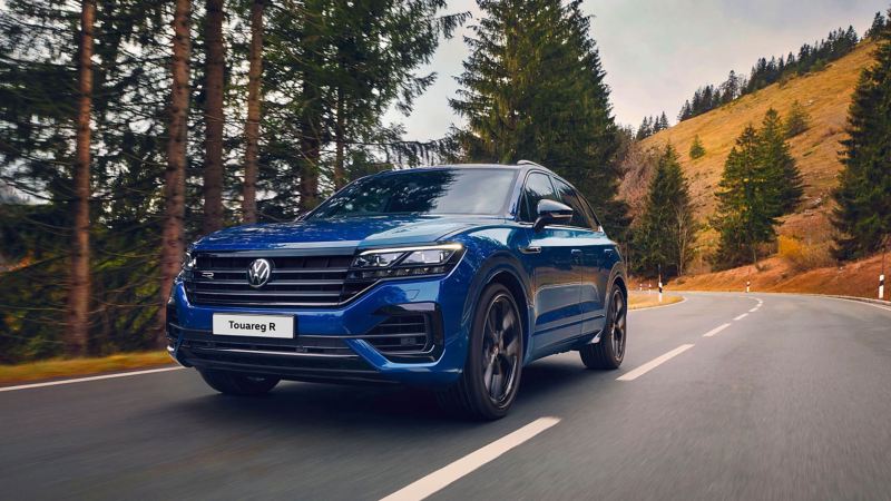 Blue Touareg R driving by countryside hills