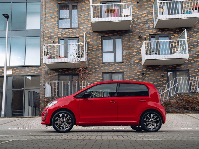 Red VW up parked in front of apartment block
