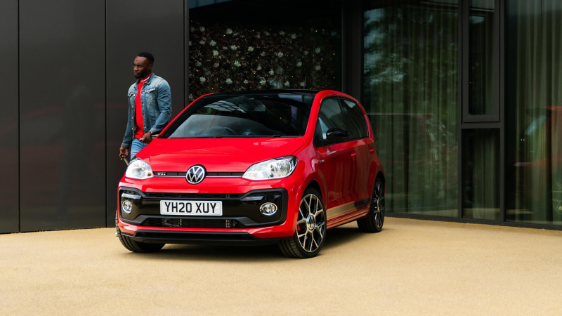 A man walking away from a red up! GTI