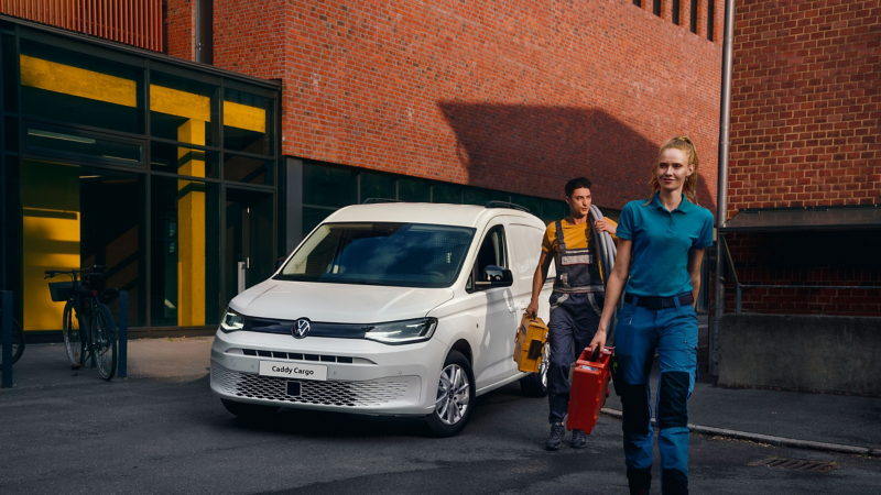 People walking next to a VW Caddy Cargo