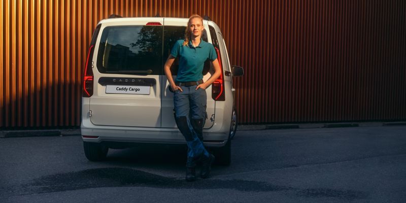 A worker leaning on the Caddy Cargo