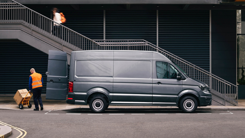 Side view of a Crafter panel van parked next to building in a city.