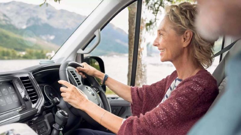 a woman driving a Grand California through the mountains