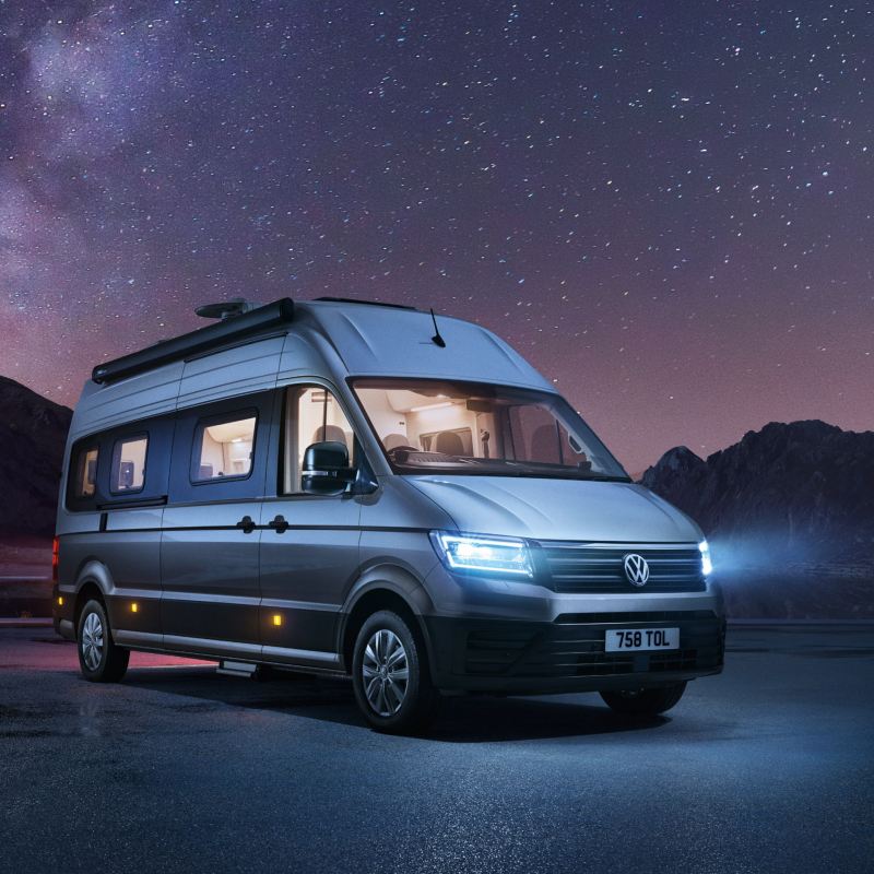 Grand California parked under starry sky with lights on