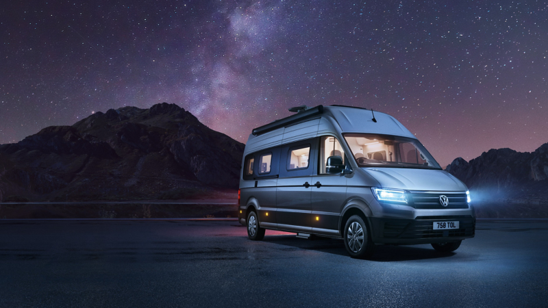 Grand California parked under starry sky with lights on