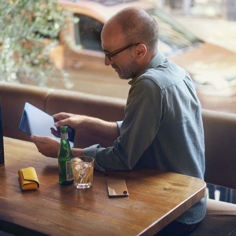 person sitting at a table using a tablet device