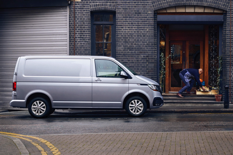 Grey Transporter 6.1 panel being unloaded outside of a restaurant. 