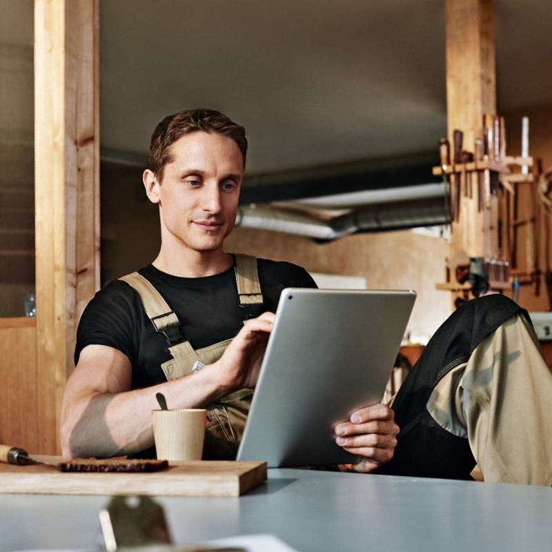 A man at a workplace browsing on an tablet
