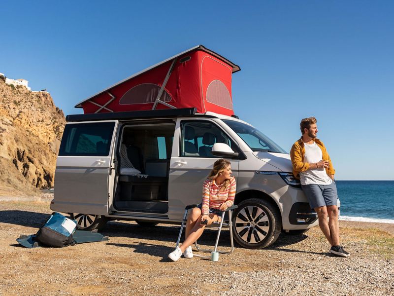 A VW California 6.1 parked at a beach with bed area deployed.