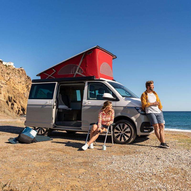 A VW California 6.1 parked at a beach with bed area deployed.