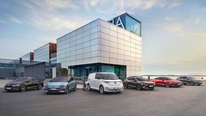 Mehrere Volkswagen Nutzfahrzeuge vor einem modernen Gebäude.