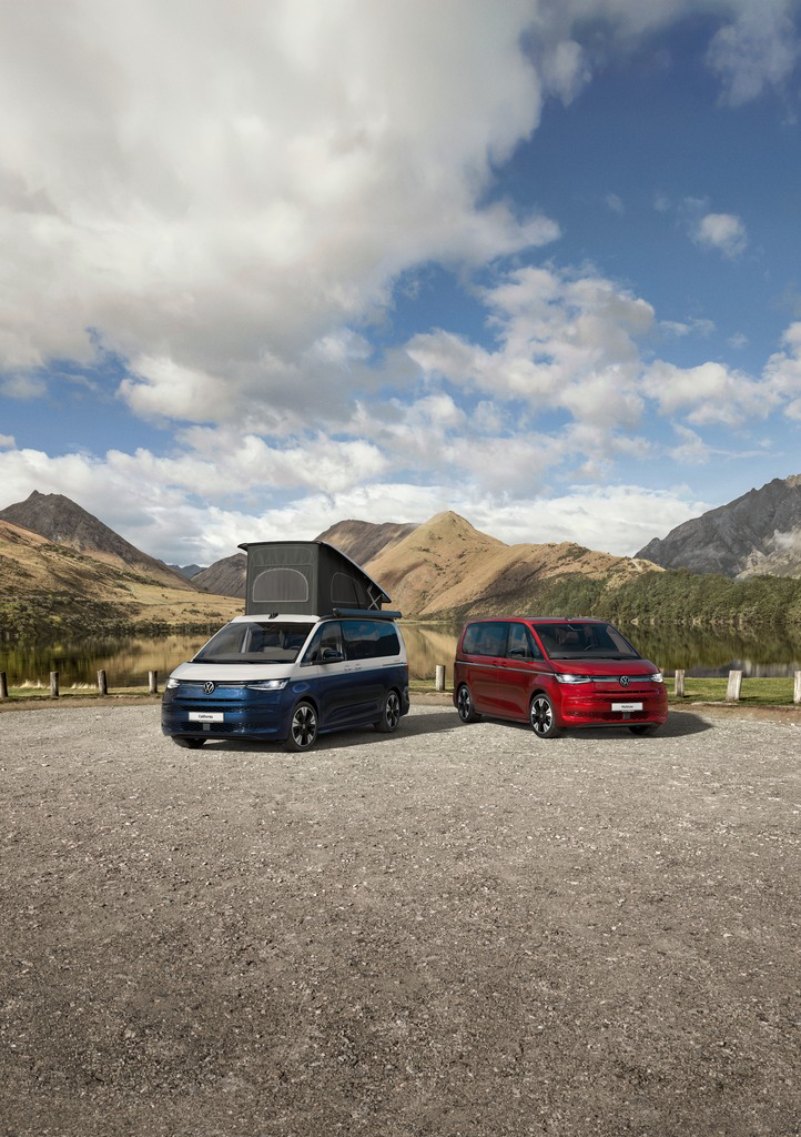 Dwa Volkswageny California stoją na parkingu w górach.