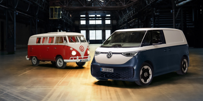 Ein VW T1 und ID. Buzz Cargo stehen in einer Lagerhalle.