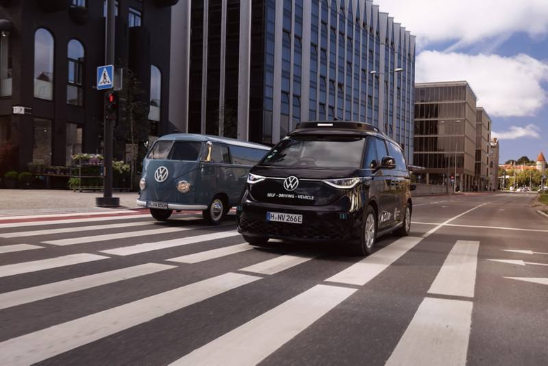 The autonomously driven ID. Buzz and a VW T1 classic car drive side by side through the city.