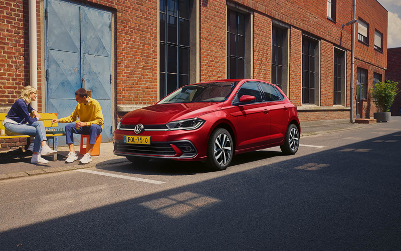Polo tussen 2 auto's ingeparkeerd en een vrouw die bij haar polo wegloopt